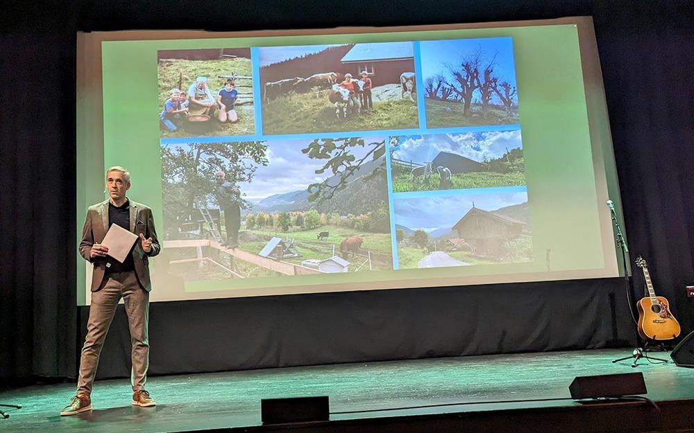 Mann framfor skjerm på scenen - Klikk for stort bilde