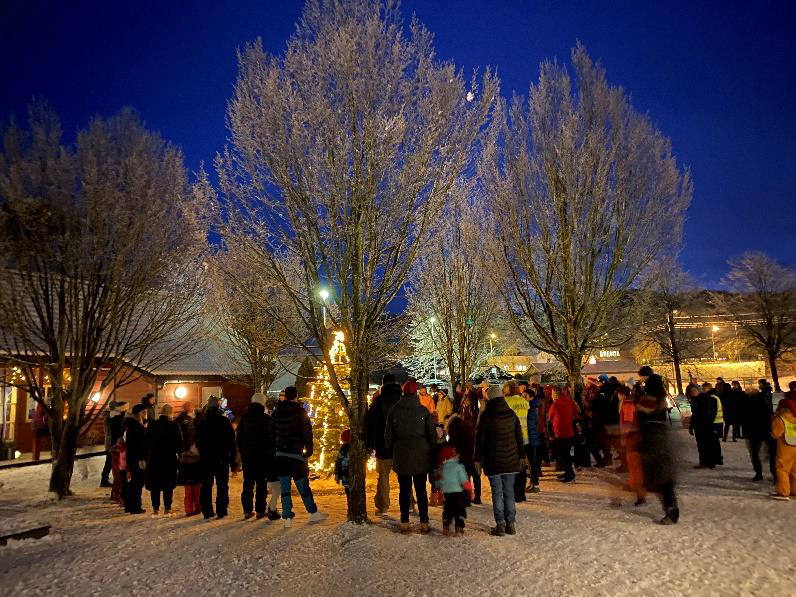 Folk som går rundt juletreet ute i barnehagen - Klikk for stort bilde